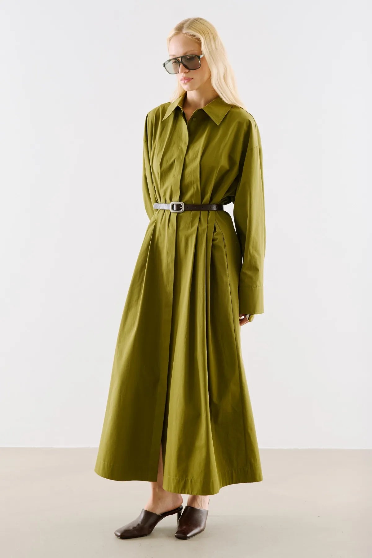 An olive shirt dress with a long, full skirt, belted at the waist.